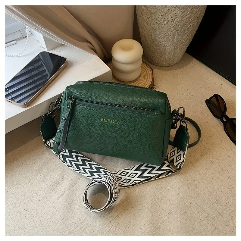 Stylish adjustable shoulder bag women small green crossbody bag with patterned strap on table