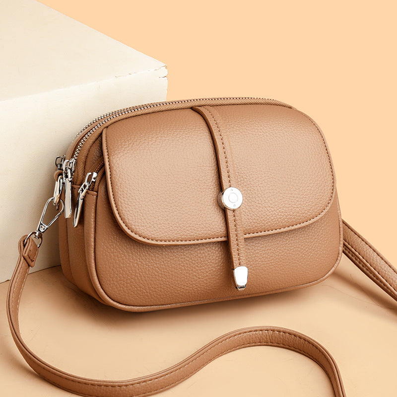 Tan city crossbody bag for women with a front flap pocket and adjustable strap