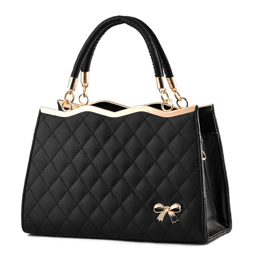 Black quilted crossbody bag with bow detail and gold-tone trim by Yiwu Renfan