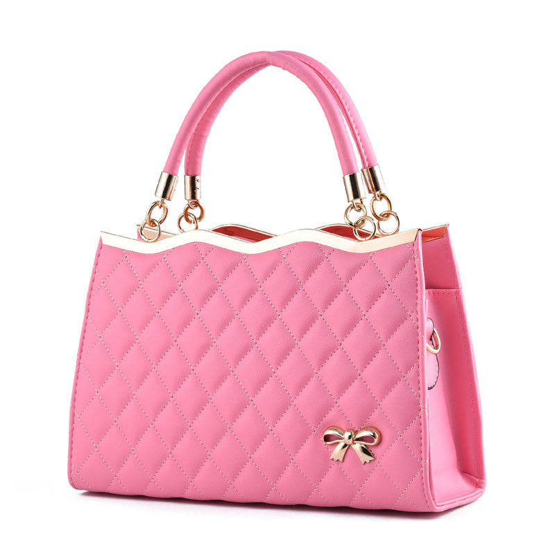 Pink quilted crossbody bag with bow detail and dual handles by Yiwu Renfan