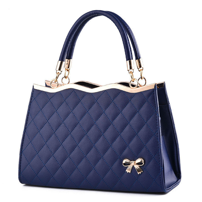 Yiwu Renfan navy blue crossbody bag with bow featuring quilted design and gold accents