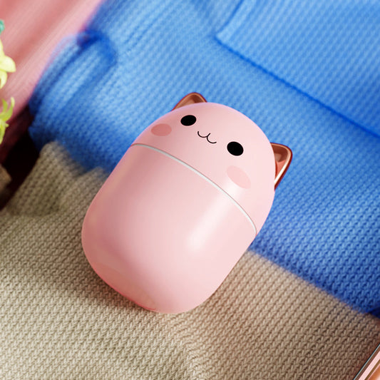 Pink portable cute cat air humidifier by Hangzhou Jingqian with smiling face and rose gold ears on knit blanket