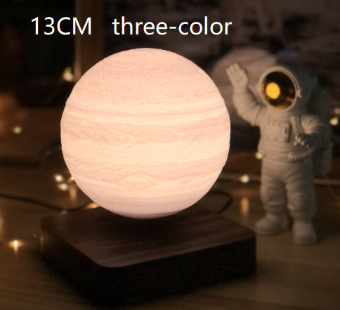 Box of Pandora magnetic levitation moon lamp glowing in three colors on wooden base with astronaut figure