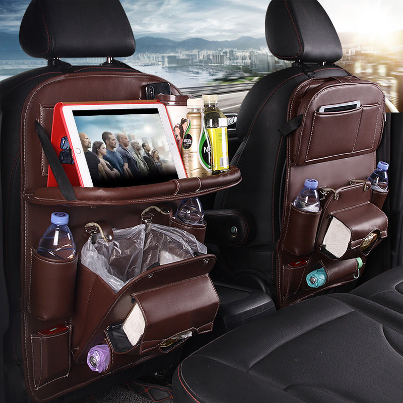Multifunction car seat tray organizer in brown leather hanging on car seat back with tablet and bottles