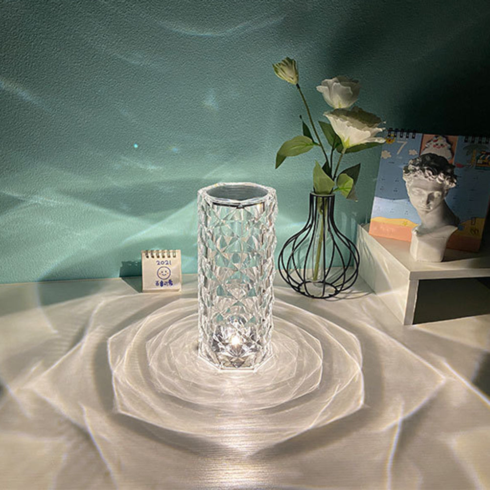 Nordic crystal lamp for bedroom on a white table casting intricate light patterns with decorative vase and statue