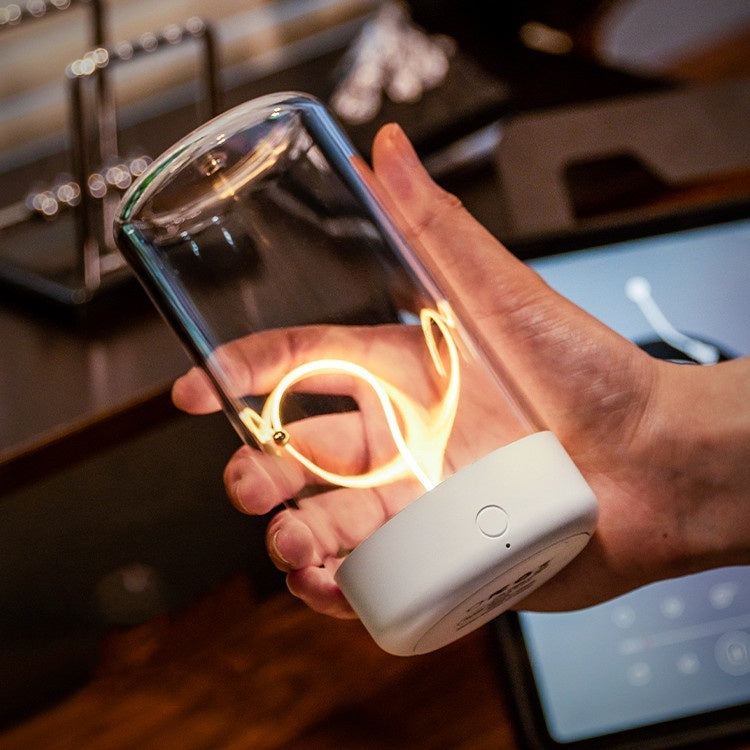 Hand holding a portable rechargeable night lamp with Type-C featuring a clear glass cover and warm filament light