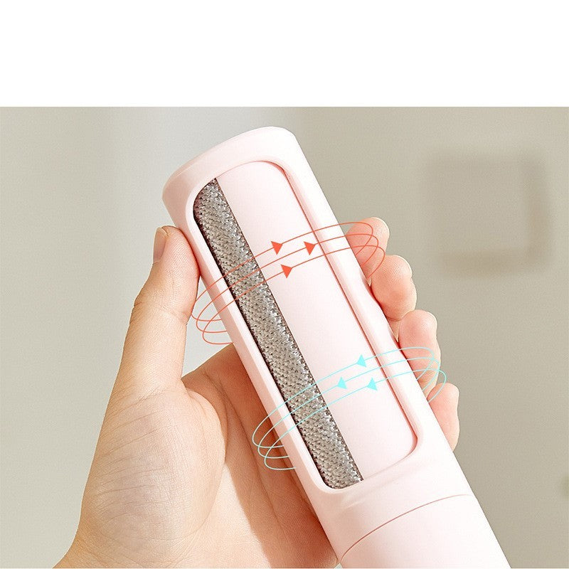 Hand holding Hangzhou Jingqian reusable pet hair remover brush in pink with cleaning feature arrows