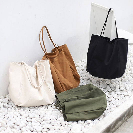 Various women's large canvas tote bags in beige, brown, black, and green for everyday use