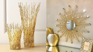 Gold sculptural twig vases and sunburst mirror with metallic accents showcasing luxury home decor accessories