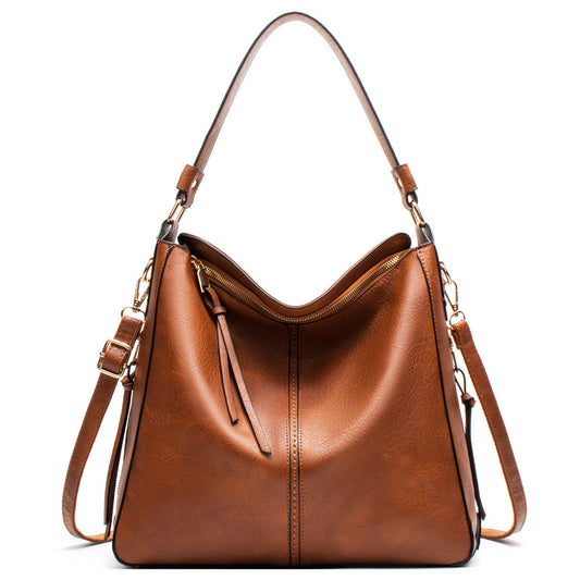 Brown leather handbag with shoulder strap on a white background