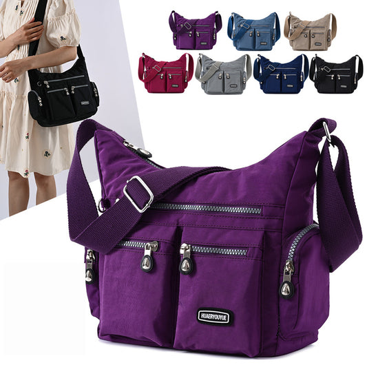Purple shoulder bag with multiple colors of bags displayed in the background