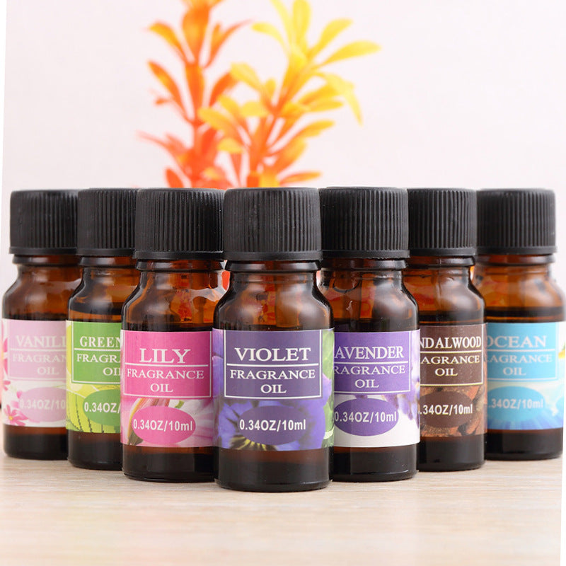 Aromatherapy essential oil humidifier with variety of fragrance oil bottles including vanilla, green tea, lily, violet, lavender, sandalwood, and ocean scents