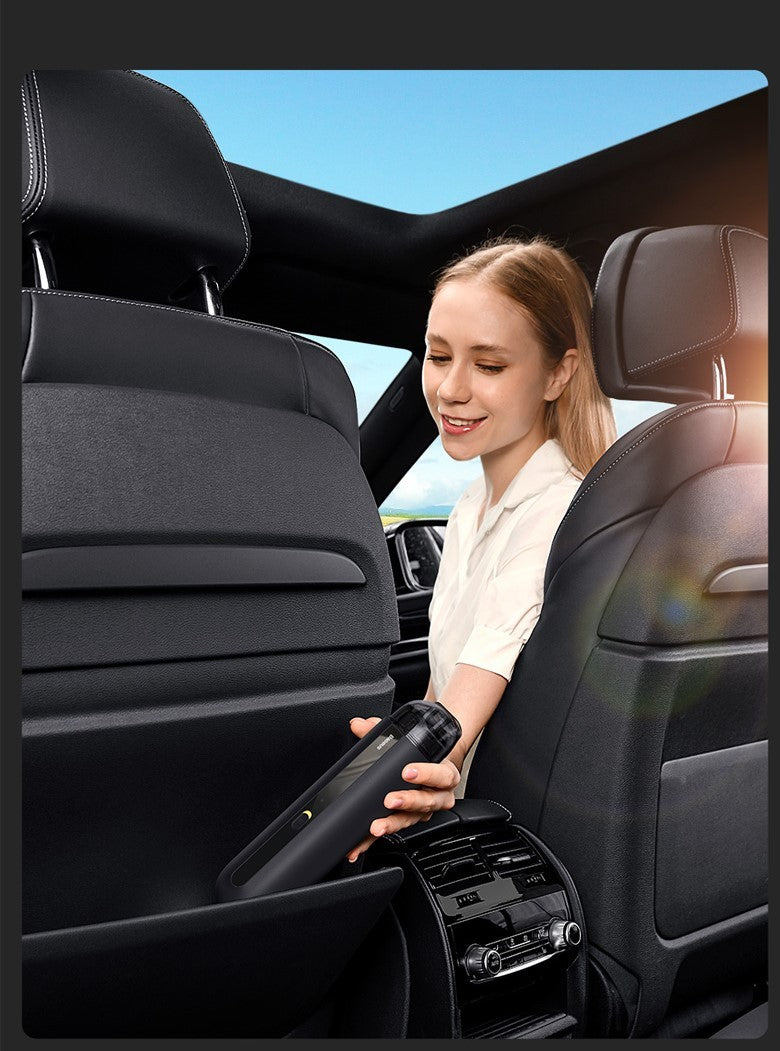 Woman using a wireless car vacuum cleaner to clean the back seat area of a black leather car interior