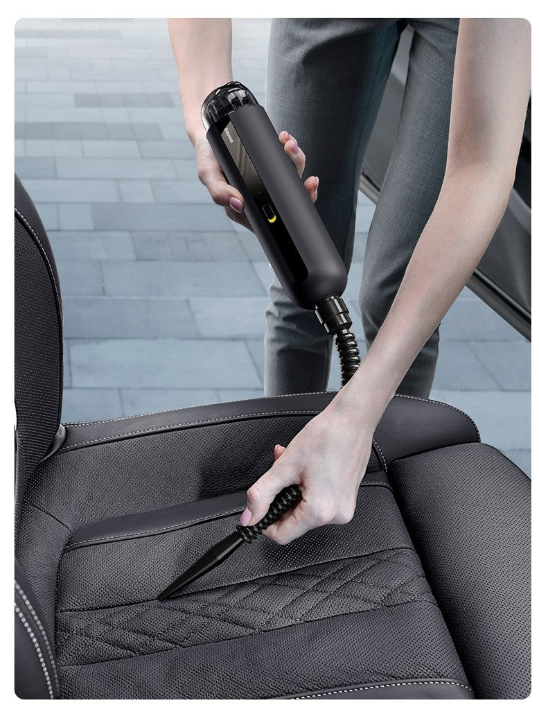 Wireless car vacuum cleaner being used to clean car seat crevices with a slim nozzle attachment