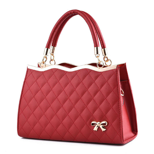 Red quilted crossbody bag with bow and dual handles by Yiwu Renfan