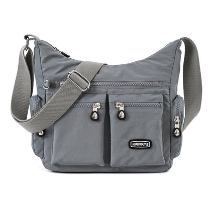Grey multi pocket crossbody bag for women with adjustable strap and multiple zippered compartments