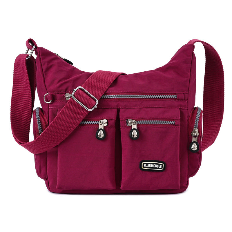 Multi pocket crossbody bag for women in burgundy with adjustable strap and multiple zippered compartments