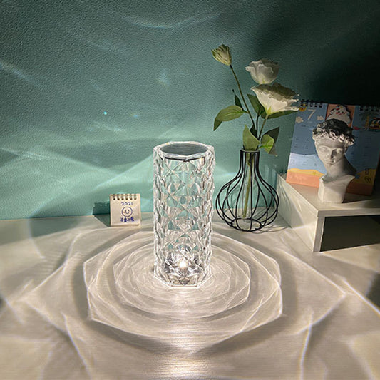 Nordic crystal lamp for bedroom on a white table casting intricate light patterns with decorative vase and statue