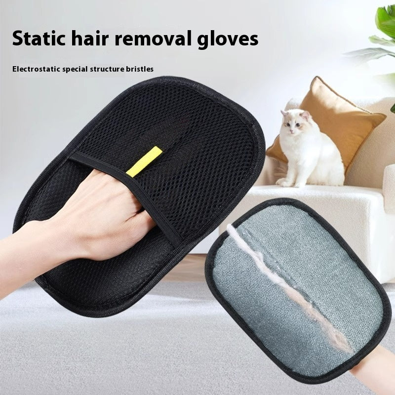 Black pet hair remover mitt with static bristles for dog deshedding held in hand near white cat on couch