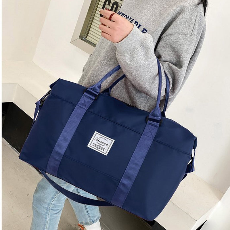 Stylish navy blue women's travel duffel bag with shoulder straps and a durable exterior