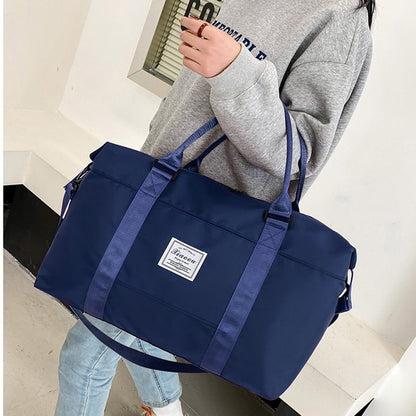 Stylish navy blue women's travel duffel bag with shoulder straps and a durable exterior