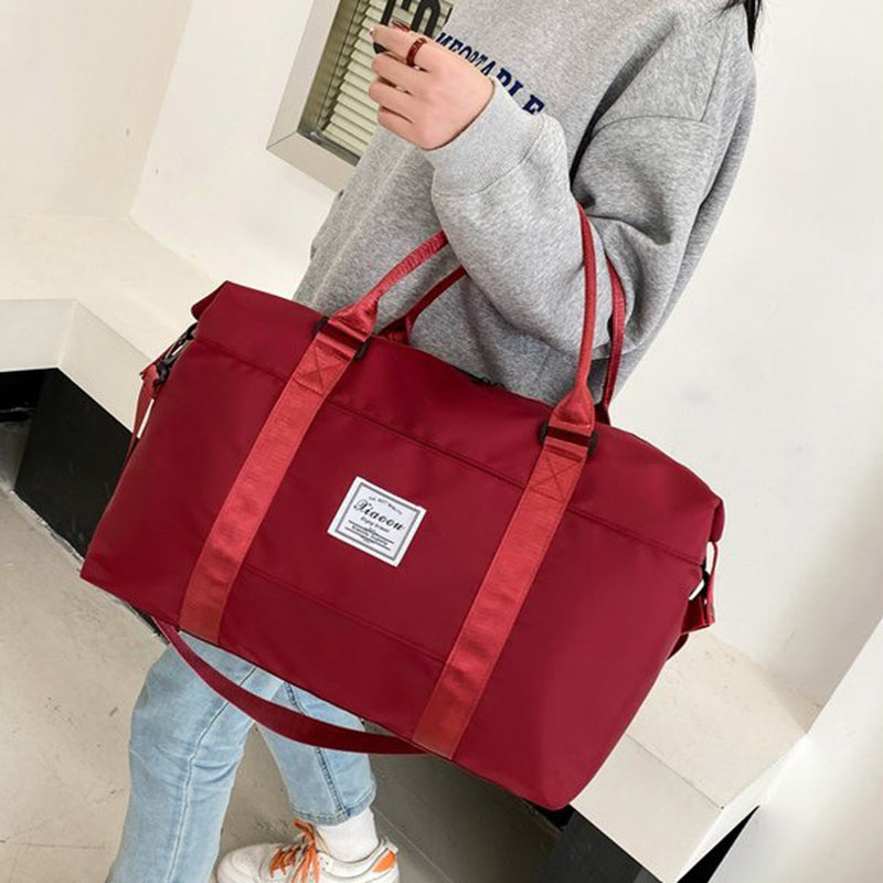 Stylish red women's travel duffel bag with adjustable straps, perfect for weekend trips