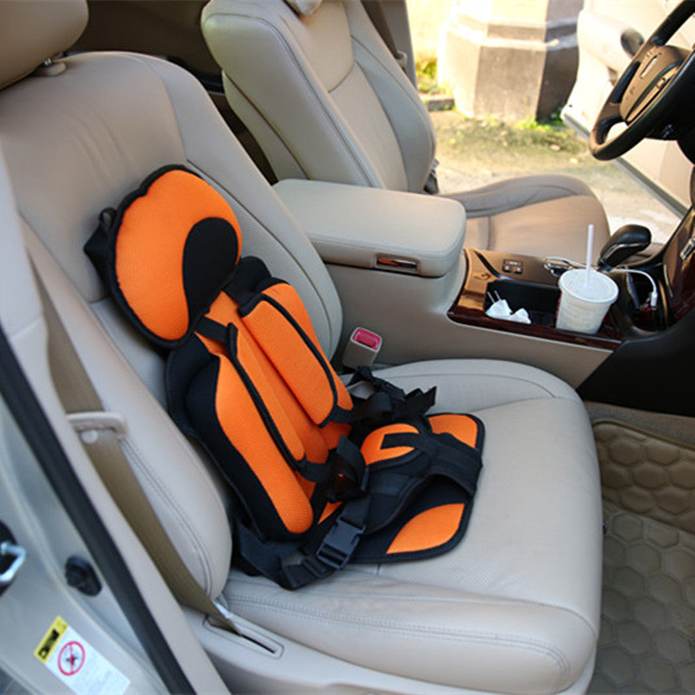Box of Pandora portable baby car seat in black and orange installed on beige car seat