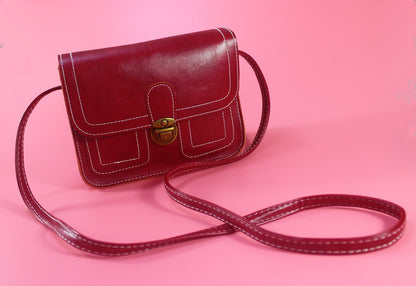 Women's vintage crossbody bag in red leather with a stylish clasp and adjustable strap