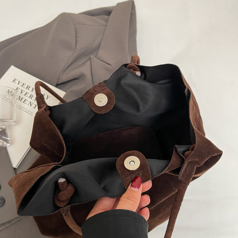 Inside view of a brown retro women's shoulder bag with soft texture and button closure