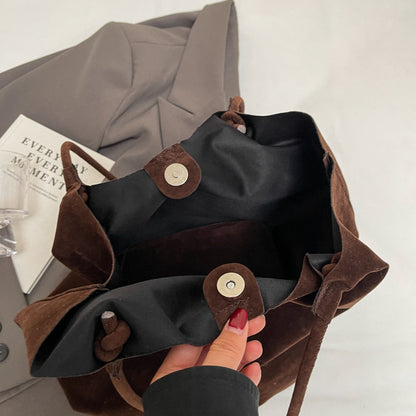 Inside view of a brown retro women's shoulder bag with soft texture and button closure