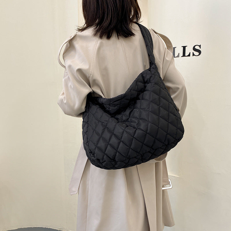 Soft warm shoulder bag for women in black, featuring a quilted design and comfortable straps