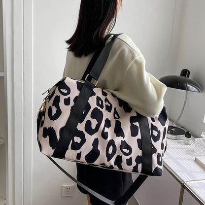 Stylish women’s cow print duffel bag with durable straps, perfect for travel or gym use