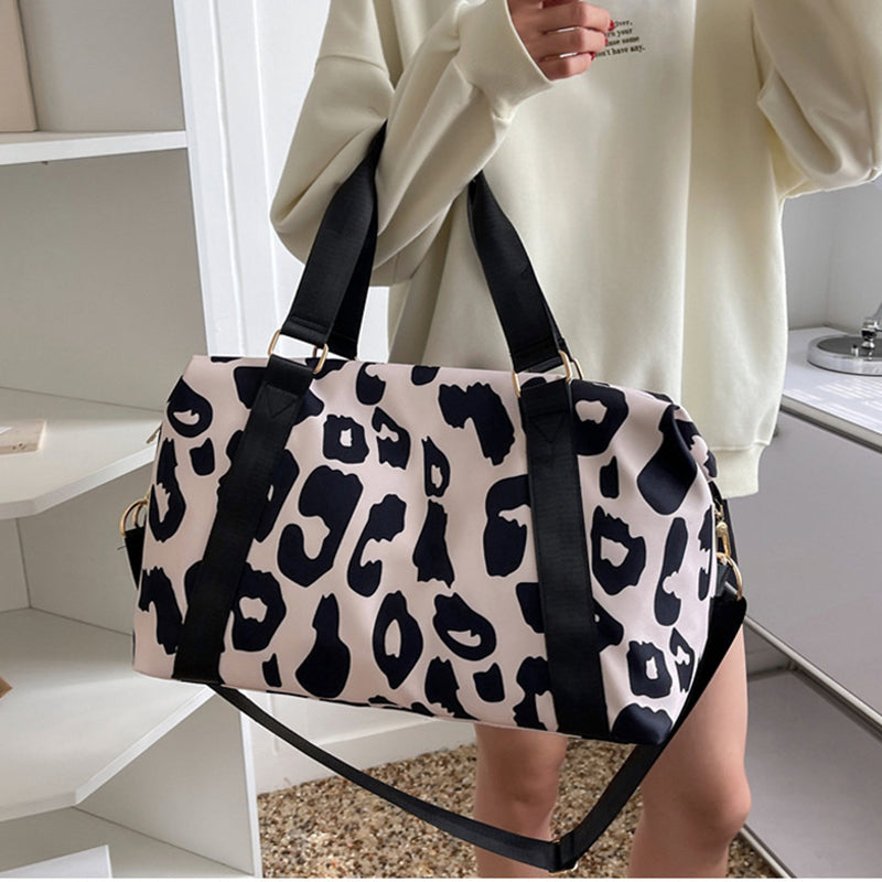 Stylish women’s cow print duffel bag with durable straps for travel and gym use