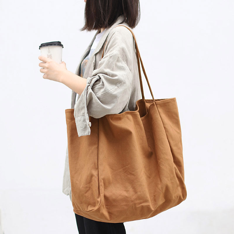 Stylish women's large canvas tote bag in brown, perfect for everyday use and errands